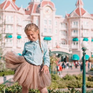 Little adorable girl in Cinderella dress at fairy-tale Disneyland park