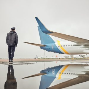 Portrait of happy confident caucasian airplane crew near plane